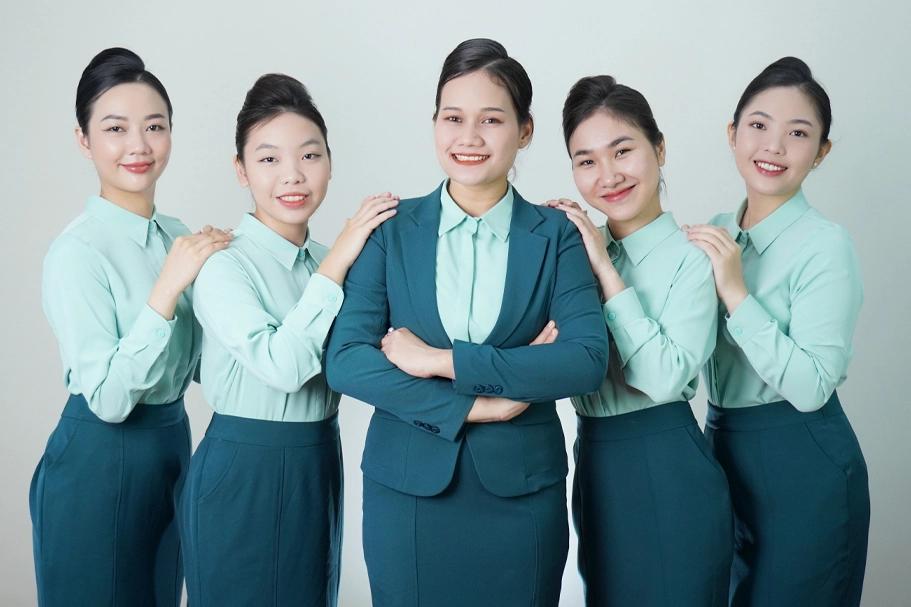 Group of five women in white lab coats standing side by side